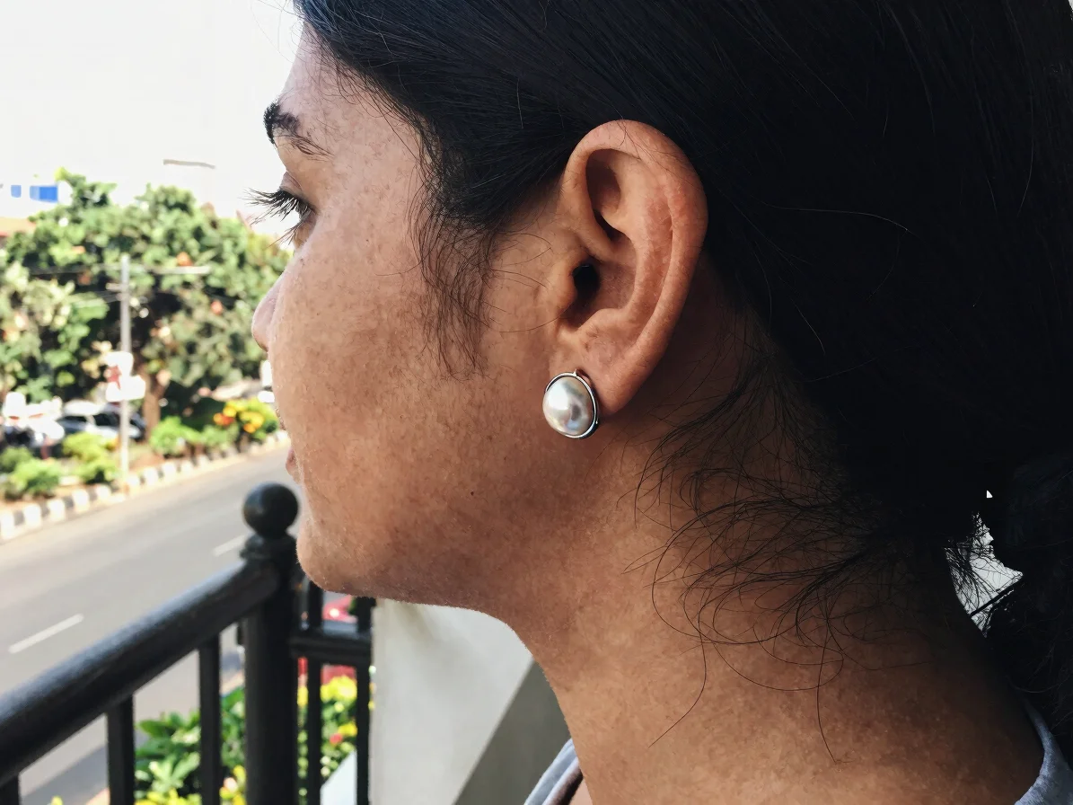 Editorial jewelry photography of a pair of artificial ear cuffs worn by a person in ordinary contemporary clothing, balc